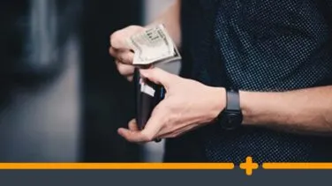 Mężczyzna wyciągający banknoty z portfela